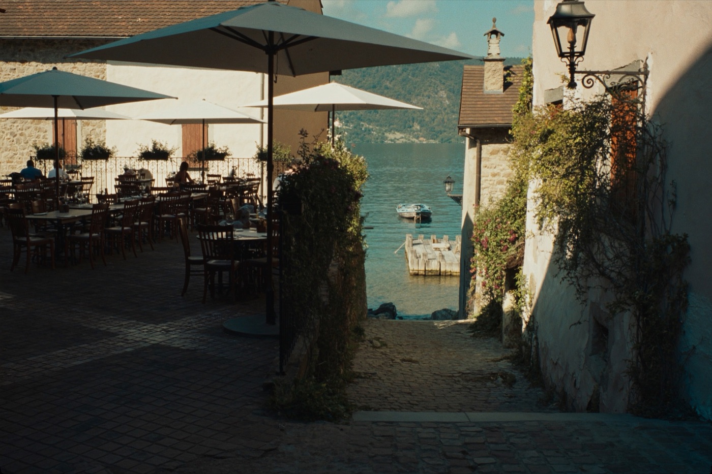 Terrasse de restaurant dans une ruelle médiévale d'Yvoire avec vue sur le lac